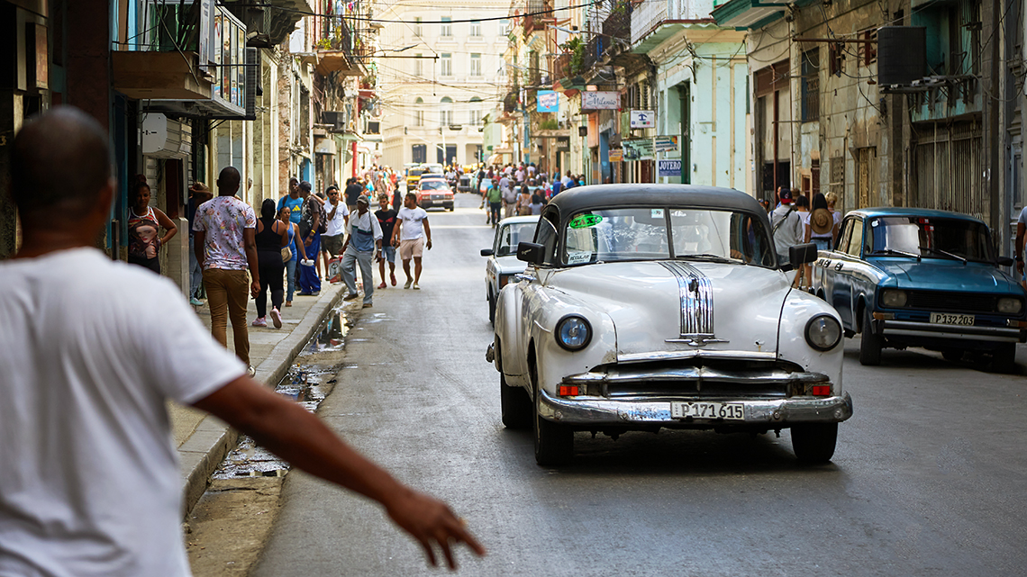 Habanero in Havana Centro making signs to stop an 'almendron', a taxi in a vintage american car, Joanna Lumley's documentary film