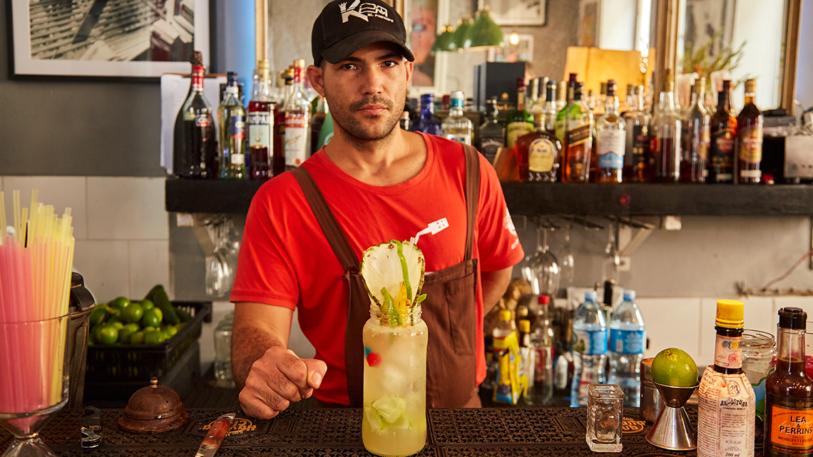 Barman prepares cocktails in the bar of Paladar El del Frente in Old Havana, Cuba
