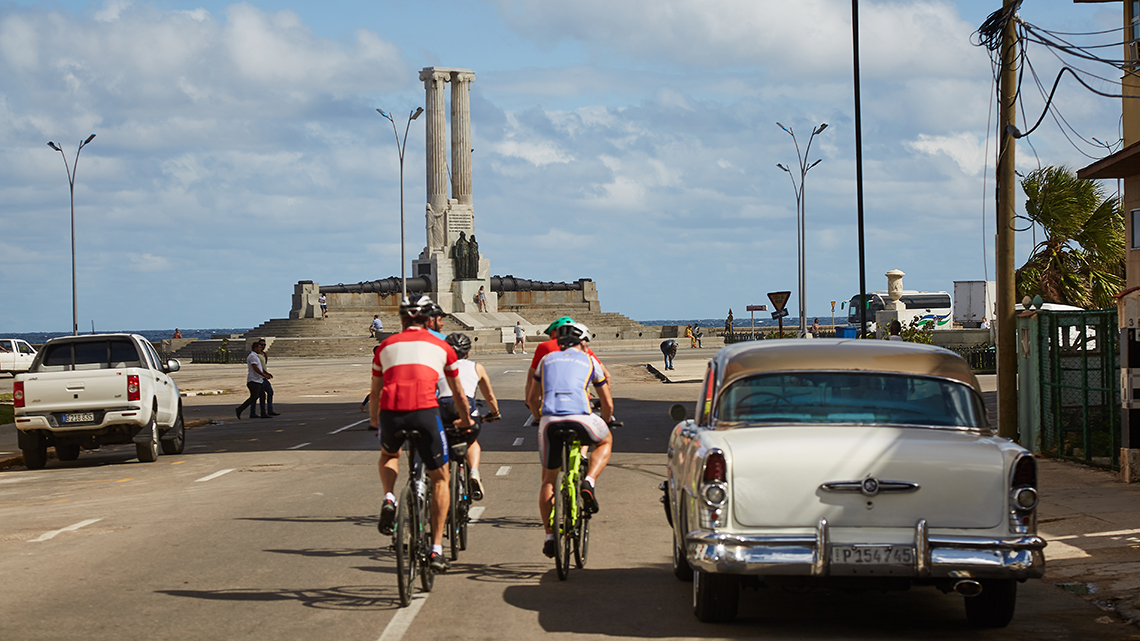 A small group of cyclists riding with Cubania Travel towards Havana's Malecon