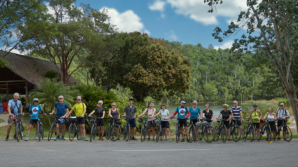 Group of cyclist pose with their Cubania Travel guides in Las Terrazas