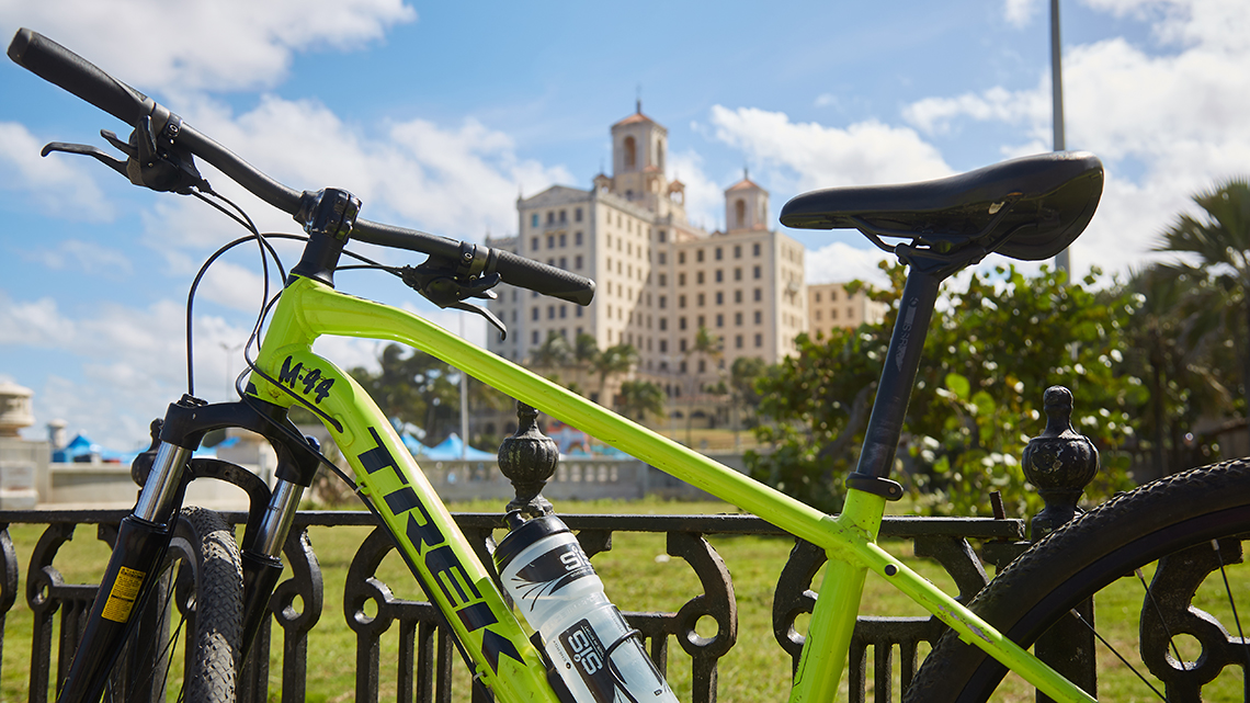 One of our bikes resting in a park in Havana, in the background the silhouette of the famous Hotel Nacional de Cuba