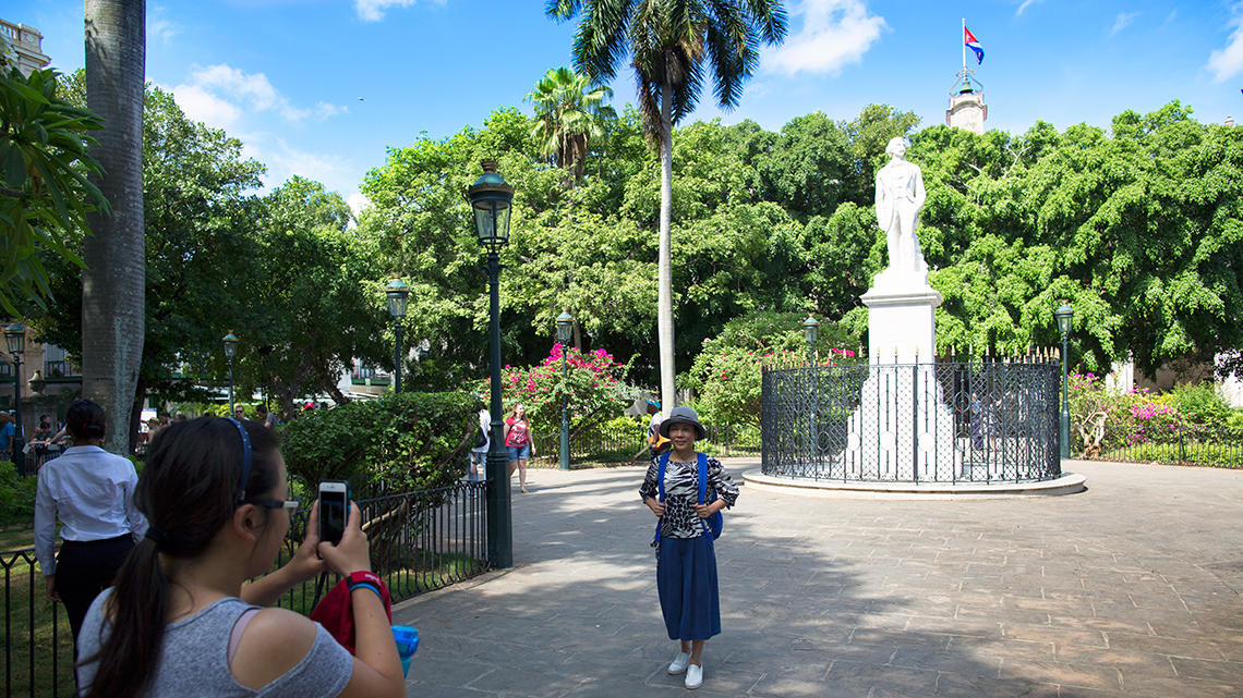 Tourist posing for a photo in Plaza de Armas in Old Havana, Cuba